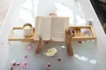 person taking a bath while reading a book
