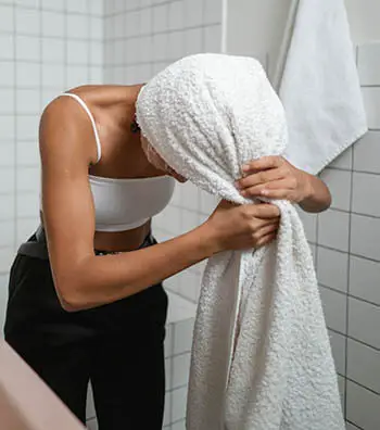 person wrapping hair in towel