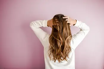 person facing backwards touching their hair